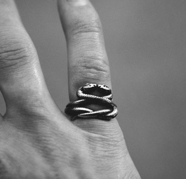 model shot of silver snake ring on hand in black and white