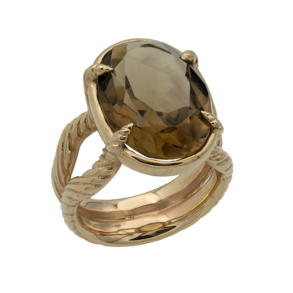 Gold ring with horn details holding a large smoky quartz stone on a white background