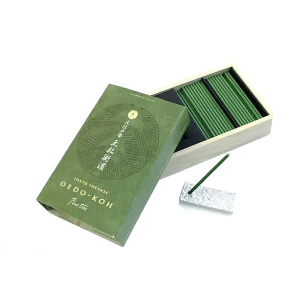 Green incense box with incense sticks on a white background