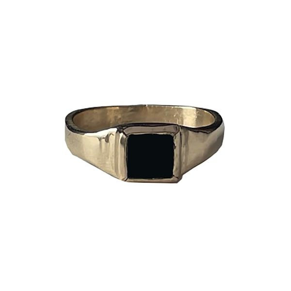 Gold ring with a black stone on a white background