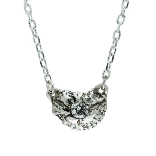 silver barnacle pendant set with white diamond on a white background