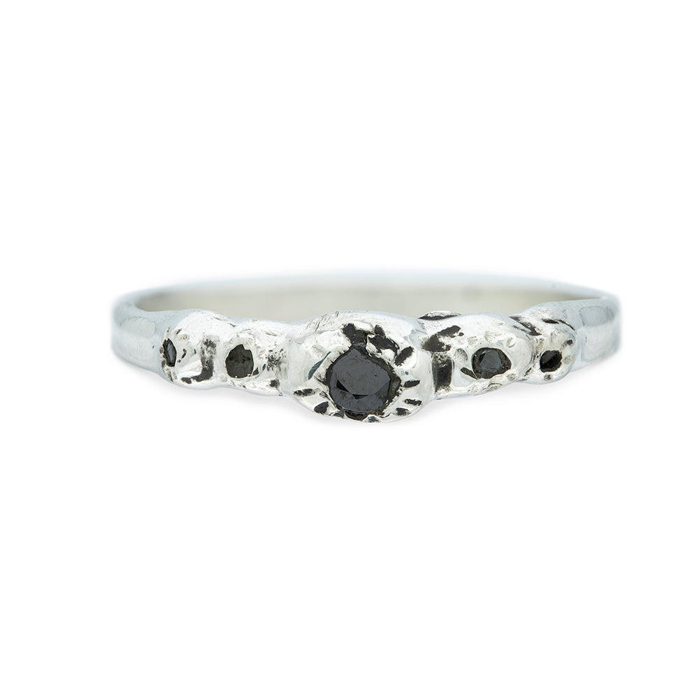 silver ring with barnacle details holding black diamonds on white background
