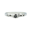 silver ring with barnacle details holding black diamonds on white background
