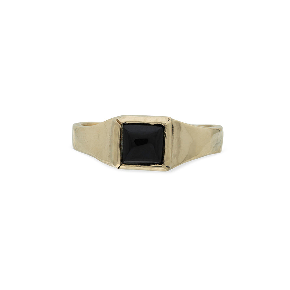 gold ring with square black whitby jet stone on white background
