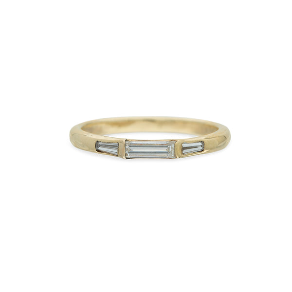 baguette diamonds in a gold ring on white background