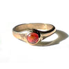 Gold ring with a red stone on a white background