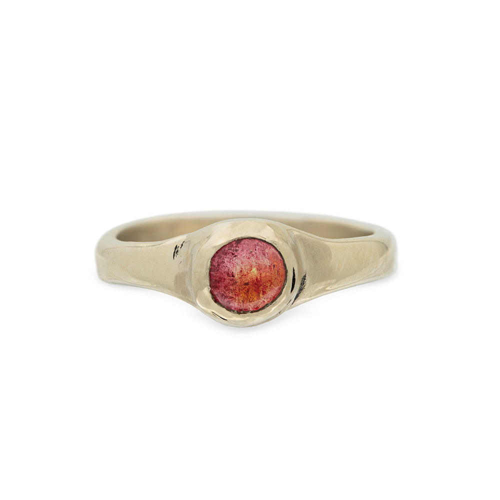 Gold ring with around  red amber stone on a white background
