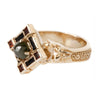 Gold ring with a green gemstone on a white background