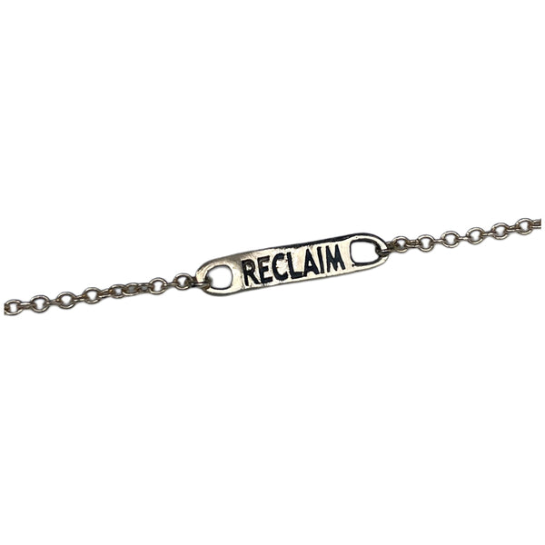 gold bracelet with 'RECLAIM' tag on a white background