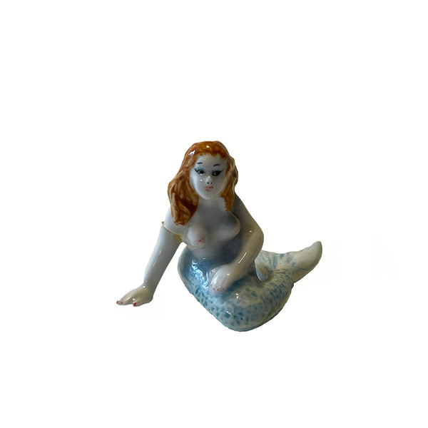 Mermaid figurine with a white body and blue tail on a white background