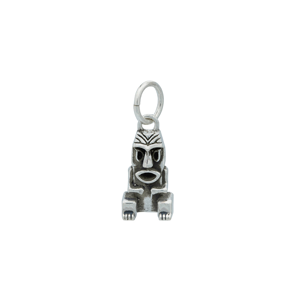 A silver Tiki charm with blackened silver details hanging from a silver jump ring.