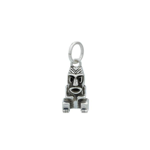 A silver Tiki charm with blackened silver details hanging from a silver jump ring.