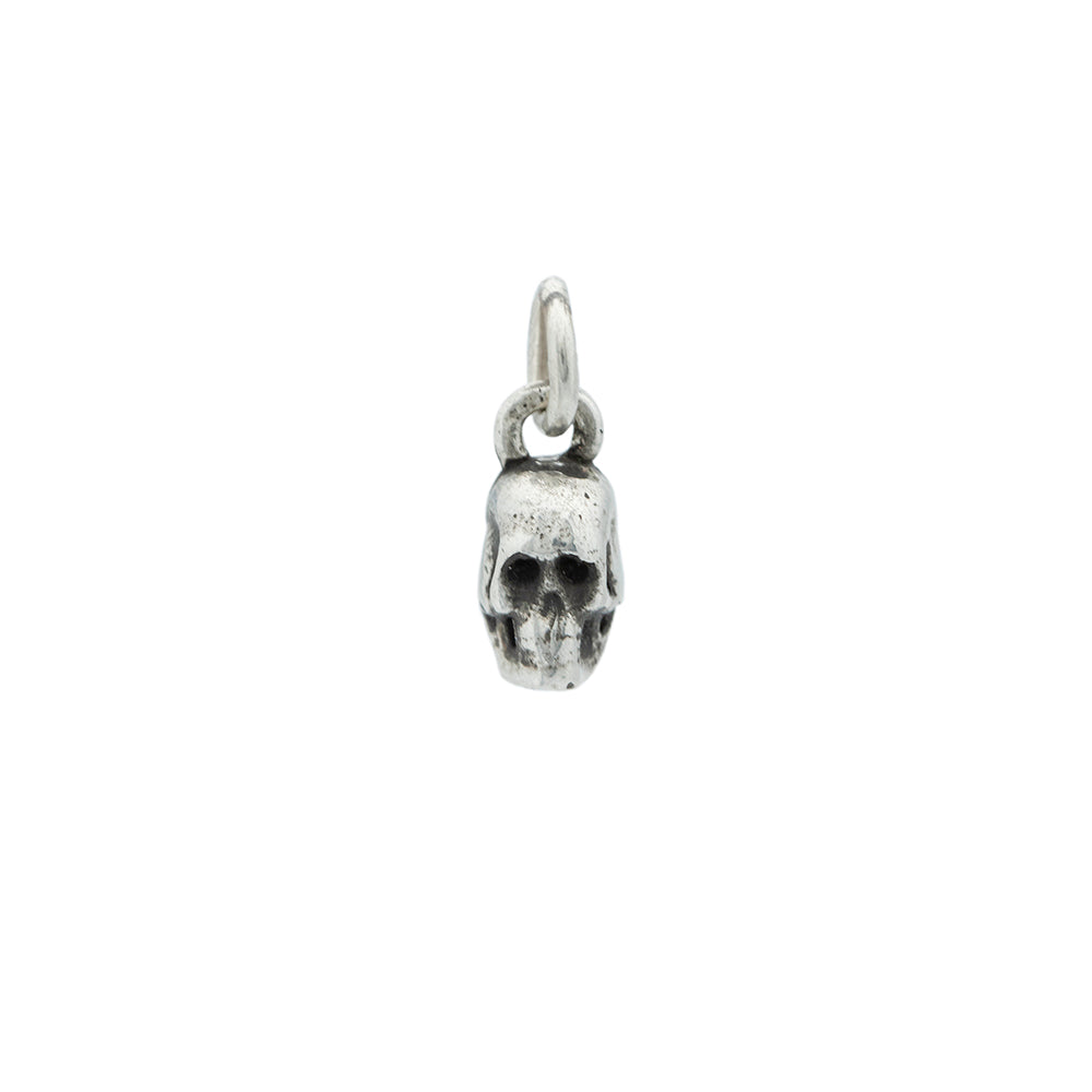 A small silver skeleton with oxidation detail  hanging from a small silver jump ring.