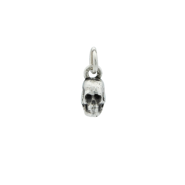 A small silver skeleton with oxidation detail  hanging from a small silver jump ring.