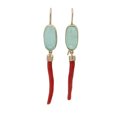 A pair of earrings with  aquamarine color oval stones set in gold holding red stick coral in gold caps, suspended from gold shepher hook ear wires.