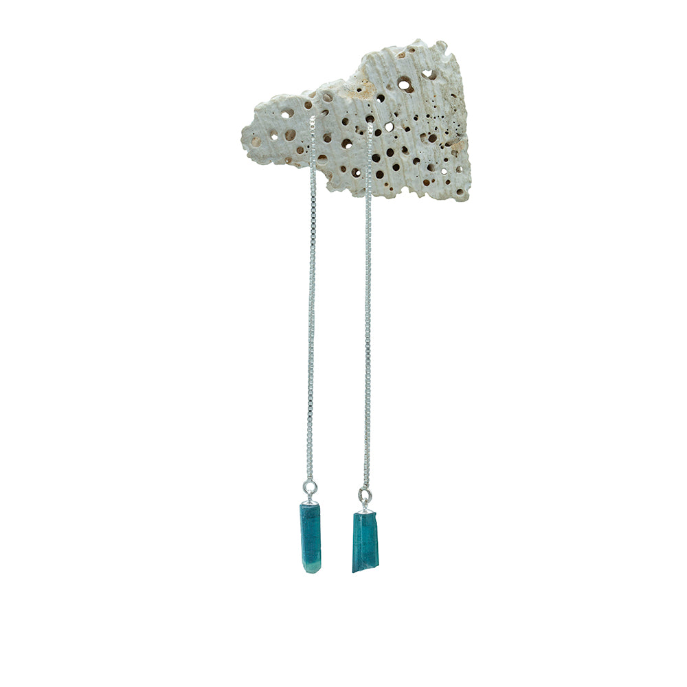 silver chain earrings with green crystals hanging from a shell bit
