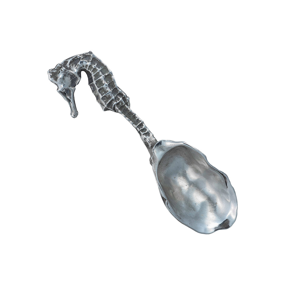 A silver spoon shaped from an oyster shell with a seahorse for the handle.