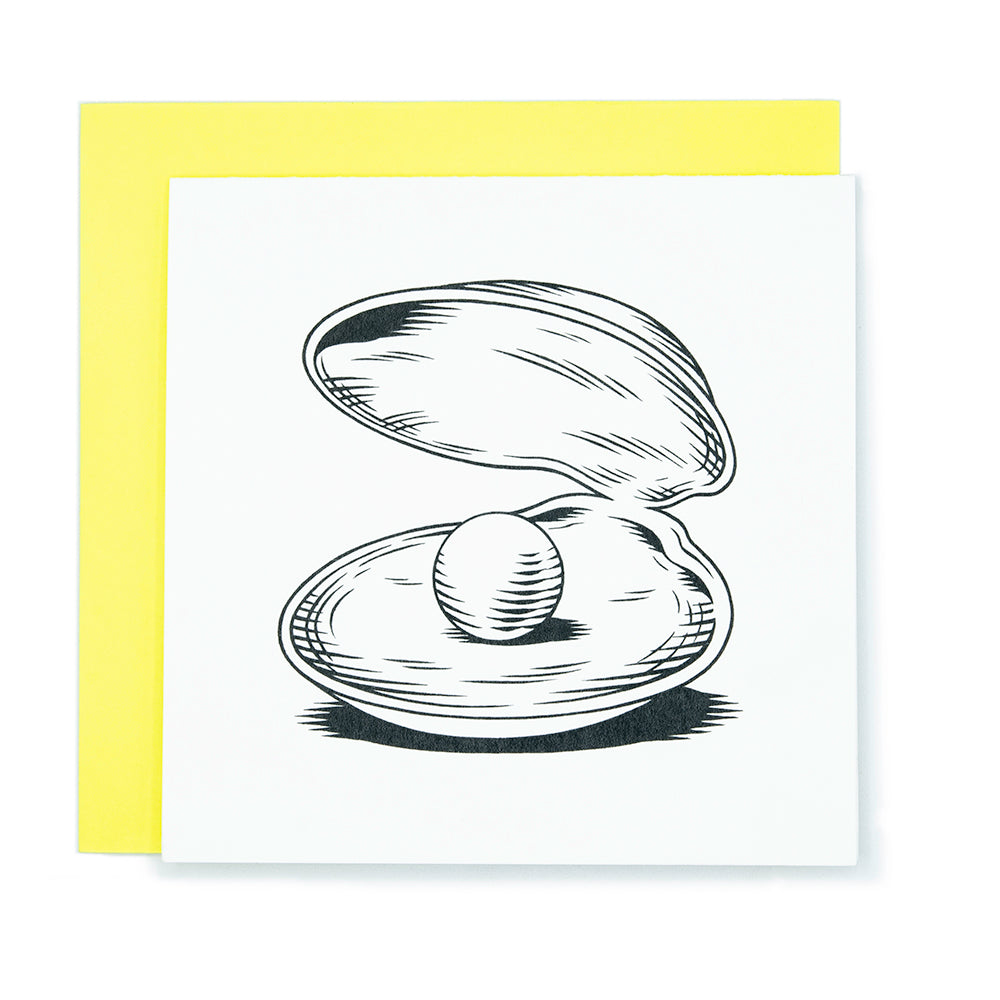 A square greeting card with an illustration of a giant pearl inside a clam shell.