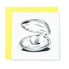 A square greeting card with an illustration of a giant pearl inside a clam shell.