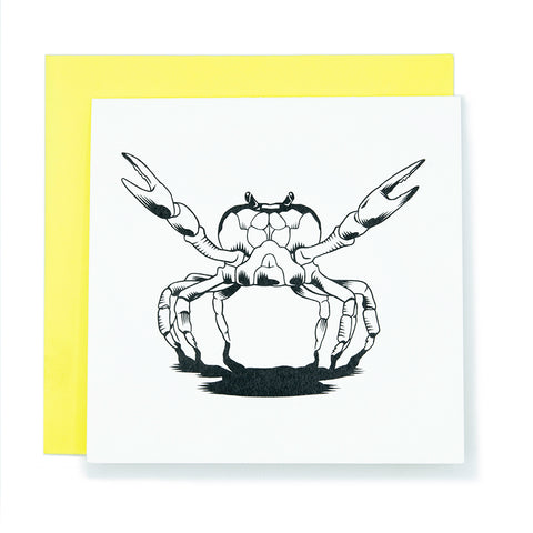 A square greeting card with a black and white illustration of a crab with its claws raised like open arms.  It sits on a bright yellow envelope background.