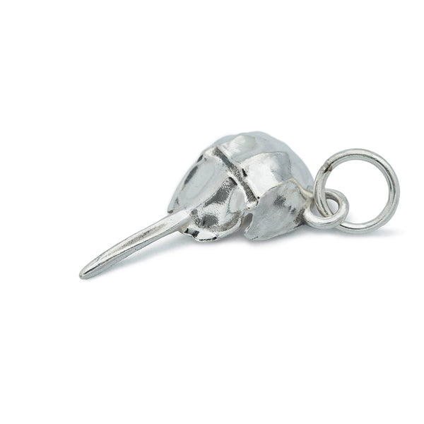 A silver horseshoe crab laying flat with a silver jump ring.