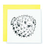A square white card with an ink drawing of a pufferfish.  The card is resting on a bright yellow envelope.