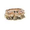 A stack of three gold rings with barnacle details  set with diamonds.