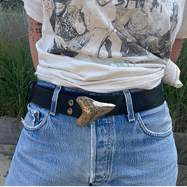 A model shot of a black belt with bronze megalodon shark tooth buckle.