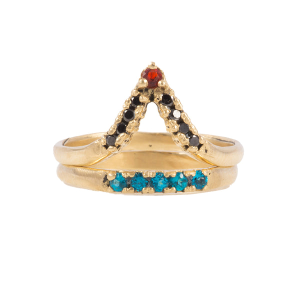 Gold ring with triangular design and gemstones on a white background