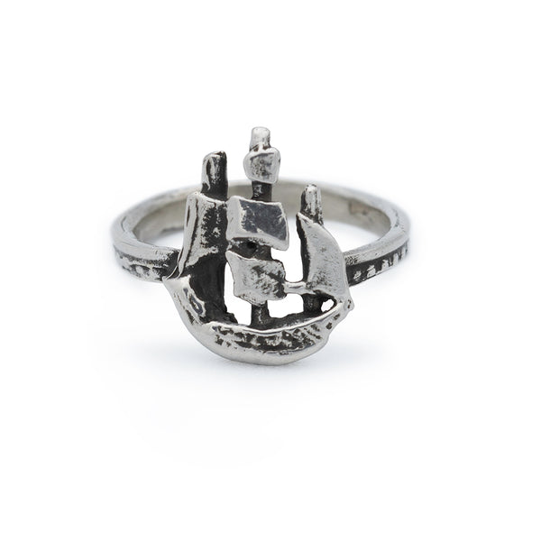 A silver ring featuring a sculpted sailing ship atop the band.
