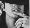 model shot of mans face, mouth open with three rings, one of them is silver spanish galleon ring