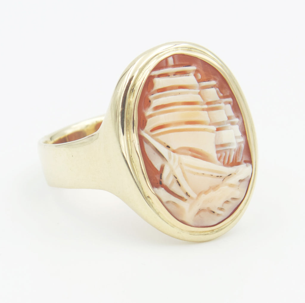 A side view of gold ring with ship cameo stone.