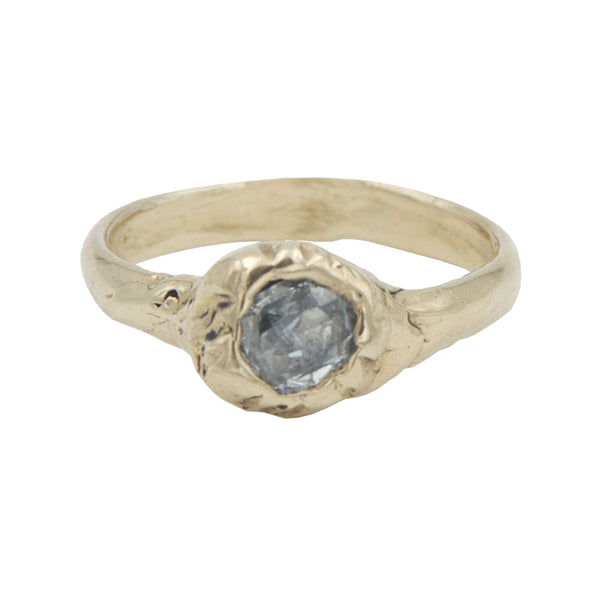 A gold ring with a barnacle detail in the center holding a grey industrial diamond.