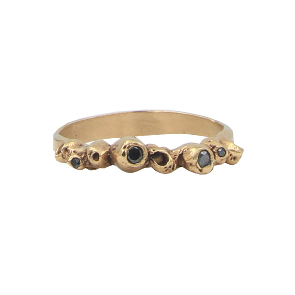 A rose gold ring with barnacle details set with black diamonds.