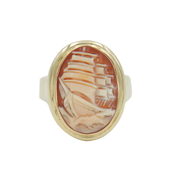 An oval shaped gold ring holding modern cameo with ship carved in cornelian shell.