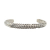 A silver cuff bracelet with a skate spine for the center showing blackened detail.