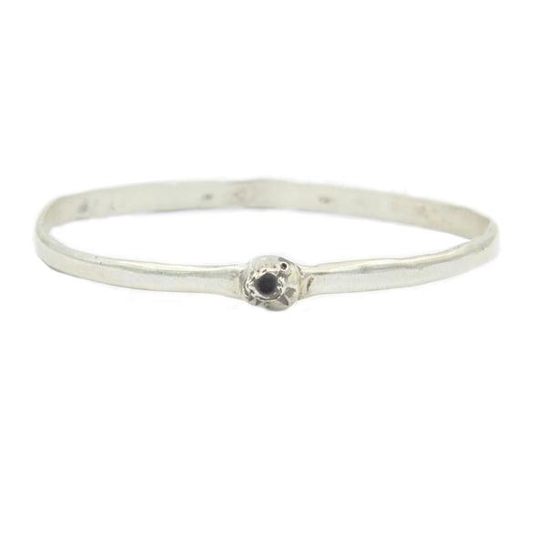 A round silver bangle style bracelet with a single barnacle  in silver.