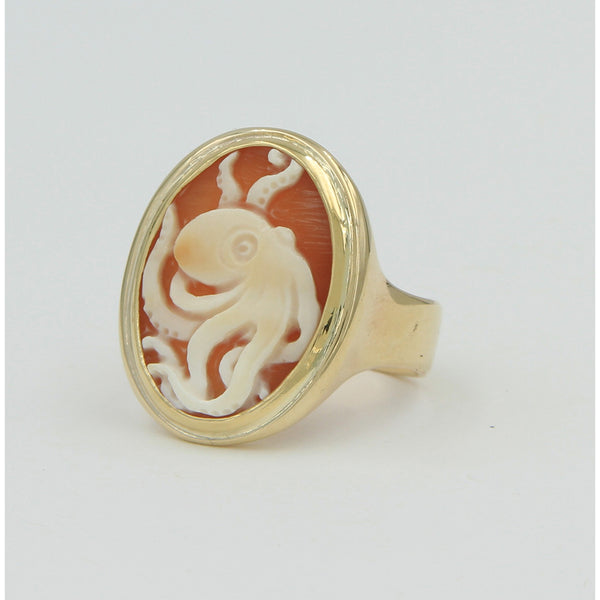 The side view of gold ring holding octopus cameo.