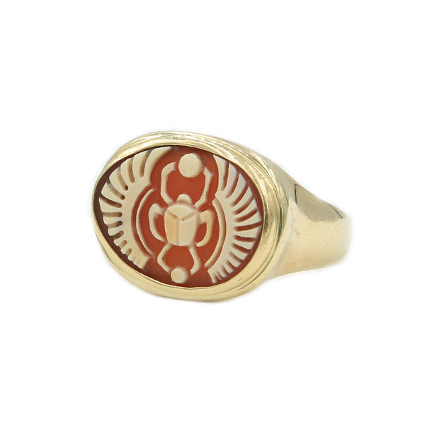 A side view of gold ring holding cameo carved with a scarab. 