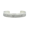 A textured silver cuff bracelet with little circlular details from skate skin.