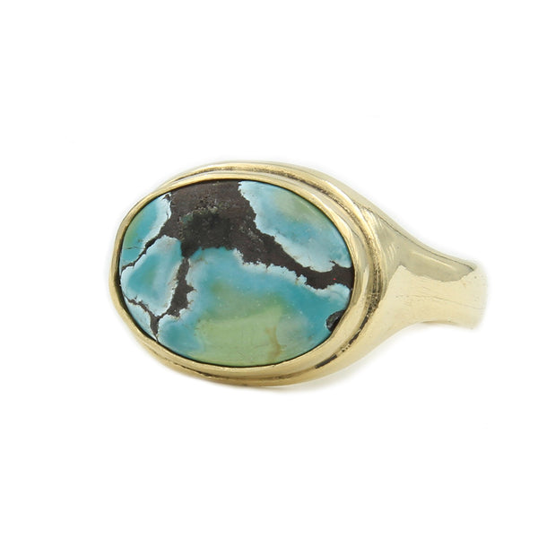 Side view of gold Ring featuring an oval turquoise stone with marbling.A gold ring featuring a sculpted sailing ship atop the band.