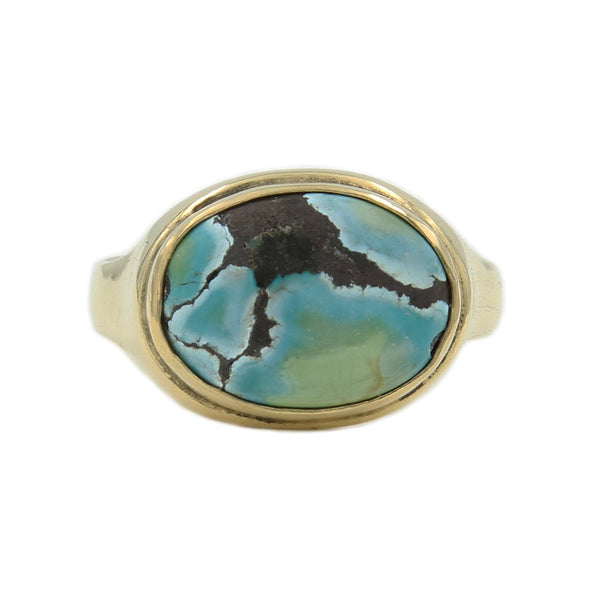 Gold Ring featuring an oval turquoise stone with marbling.A gold ring featuring a sculpted sailing ship atop the band.