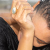 A model shot of gold ring with oval metallic osmena pearl worn by a girl in the ocean.
